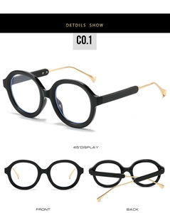 Detail of round black frame glasses with thin gold metal temples and retro stylish design
