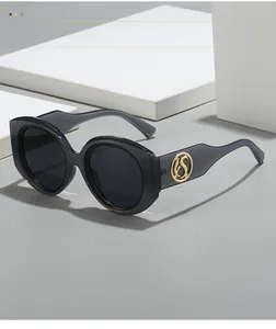 Détails de lunettes de soleil oversize gris foncé translucides avec décorations dorées sur les branches