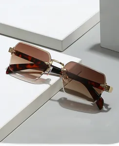 Close-up of frameless rectangle sunglasses with brown gradient lenses and gold metal bridge