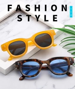 Detail of yellow and tortoise shell vintage sunglasses with studs on marble surface