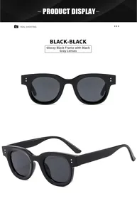 Detail view of oval sunglasses featuring silver metal studs and glossy black frames