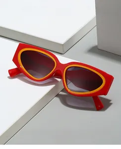 Detail of 2024 cat-eye sunglasses with red and yellow frame on geometric blocks