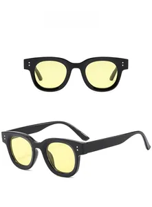 Detail of oval black frames with yellow lenses and silver rivet accents for sunglasses