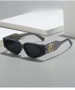 Detail of grey translucent frame sunglasses with golden S logo on the temple