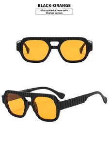 Detail of aviator sunglasses featuring a textured black frame and vibrant orange lenses