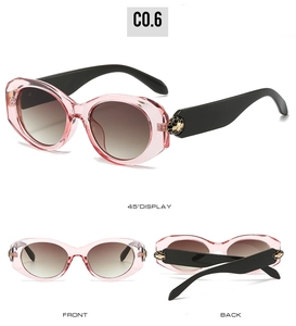 Detail of pink oval sunglasses with gold honeycomb hinge and gradient lenses