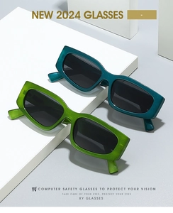 Close-up of retro oversized thick frame sunglasses in teal and bright green acetate