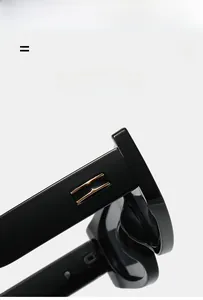 Close-up of black square sunglasses with metallic golden temple accents and glossy finish