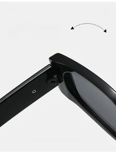 Close-up of durable metal hinge on black oversized sunglasses frame with polished finish