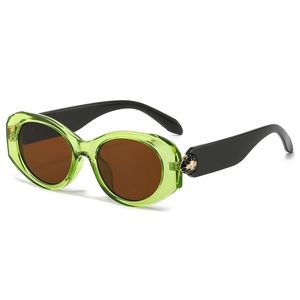 Oval green frame sunglasses with gold snake emblem and dark lenses on a white background