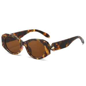 Oval tortoiseshell sunglasses with dark brown lenses and golden hexagonal hinge details