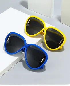 Detail of yellow and blue oversized sunglasses with signature gold metal arrow accents