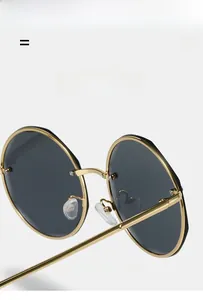 Detail of round sunglasses featuring lightweight, elastic gold metal frames and black lenses