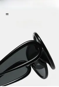Detail of glossy black oversized sunglasses showing lightweight hinge and polarized lenses
