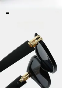 Makroaufnahme der goldenen Metallscharniere an einer schwarzen eckigen Sonnenbrille