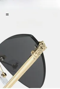 Détail de la branche en métal doré avec sculpture tête de léopard sur lunettes sans bord