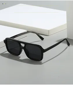 Detail view of high-quality vintage square black sunglasses on a textured gray background