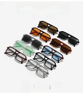 Flat lay of multiple colorful vintage double-bridge sunglasses with thick frames and diverse lenses