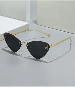 Detail of rimless cat eye sunglasses featuring gold metal temple and crystal F logo