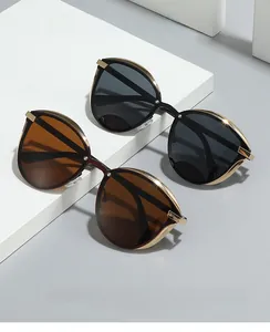 Detail of retro cat-eye sunglasses with gold metal frames and gradient tinted lenses