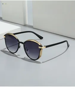 Close-up of black cat-eye sunglasses with gold metal accents and gradient lenses