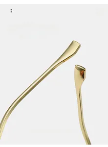 Macro detail of curved gold metal temples and anti-slip tips for rimless sunglasses