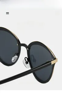 Detail of black oversized sunglasses frame with elegant golden metal hinge accents