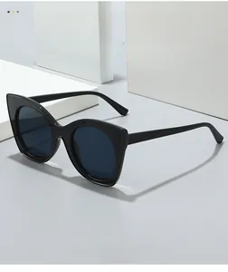 Détail de lunettes de soleil œil de chat noires avec monture épaisse brillante et verres