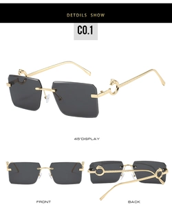 Macro detail of rimless gold sunglasses with leopard head hinge and gray cut lenses