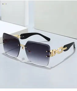Detail of rimless sunglasses featuring grey gradient lenses and golden chain temple bars