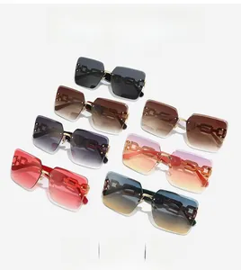 Detail of oversized rimless sunglasses featuring stylish metal chain design temples