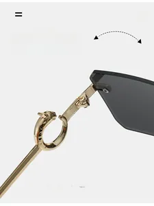 Macro detail of gold leopard head metal hinge and dark grey rimless lens on sunglasses