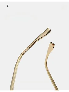Close-up of polished gold metal curved temples on trendy rimless sunglasses