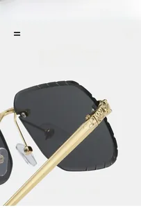 Détail de lunettes de soleil carrées sans monture avec relief panthère en métal doré