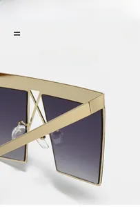 Macro view of gold metal square sunglasses frames with gradient lenses and cross bridge detail