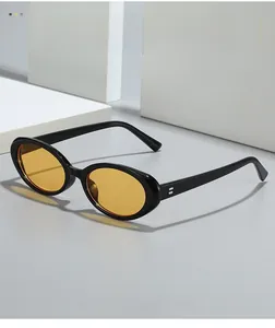 Macro detail of retro oval glasses with thick black frames and orange lenses in soft lighting
