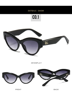 Detail view of cat eye sunglasses with purple gradient lenses and gold logo hinges