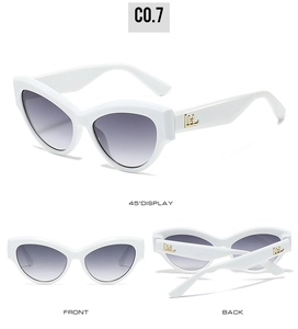 Detail view of white cat eye sunglasses with gold accents and gradient lenses