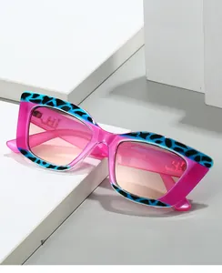 Detail of pink cat-eye sunglasses with blue leopard print top and gradient lenses