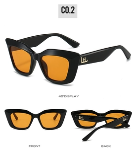 Detail view of cat eye sunglasses with thick black frames and orange lenses showing all angles