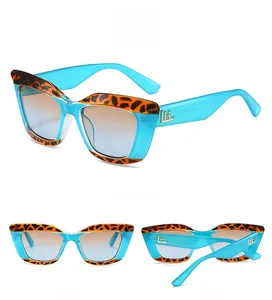 Detail view of cat-eye sunglasses featuring leopard print trim and blue gradient lenses