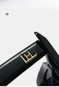 Detail of black cat-eye sunglasses featuring golden geometric logo on lightweight temples