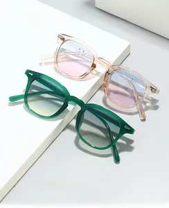 Detail of square glasses frames in green and peach colors on minimalist geometric steps