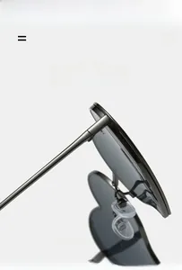 Détail de lunettes de soleil cœur en métal gris montrant la charnière et la branche