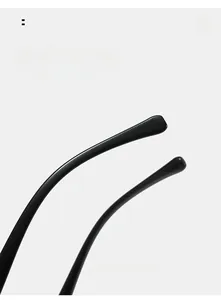 Close-up of curved black mirror legs and rounded tips on oval glasses frame