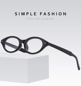 Side view of black oval cat-eye frames with metal rivet detail on white geometric display