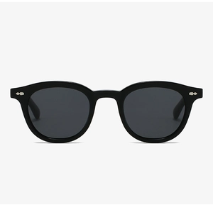 Detailed view of black oval sunglasses frames with silver rivet accents and dark lenses