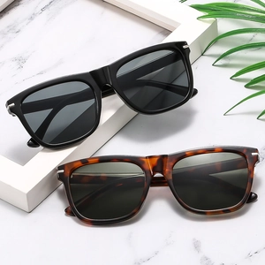 Detailed view of black and tortoiseshell square sunglasses with silver metal rivets