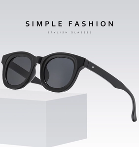 Detail of black thick frame sunglasses with dark lenses on a white geometric stand