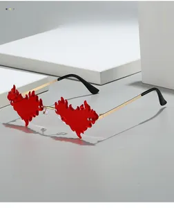 Détail des lunettes de soleil flamme en forme de cœur rouge et branches dorées